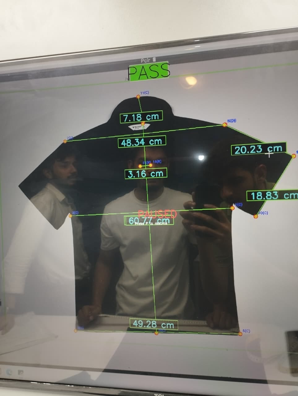 The measurement view: a shirt checked to spec, PASS, every panel dimension in centimetres.